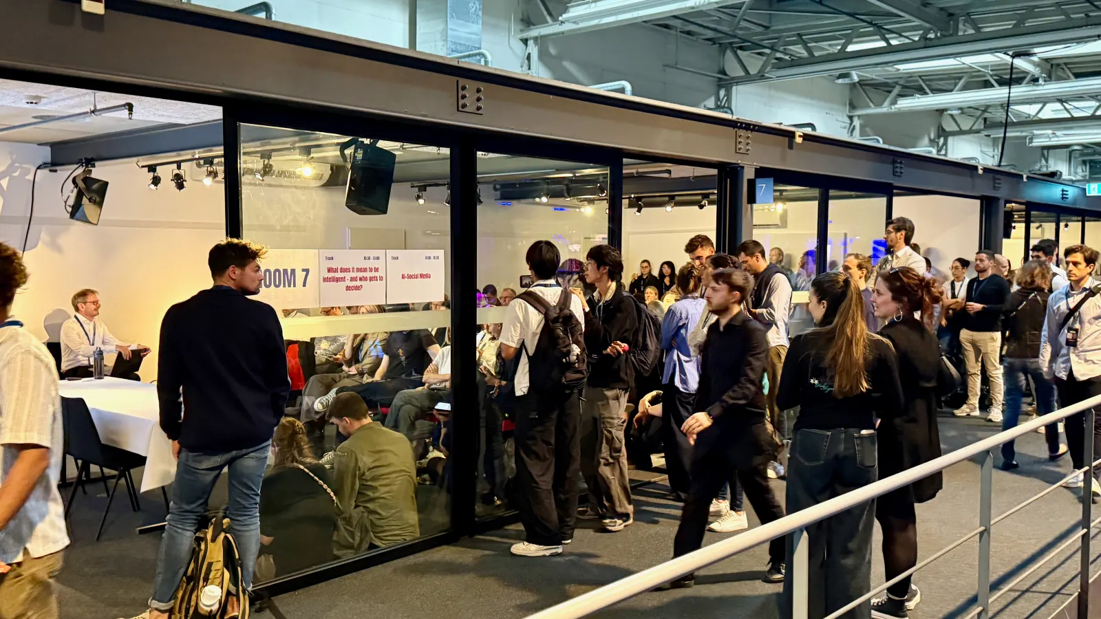 A crowd outside the glass walls of the session room